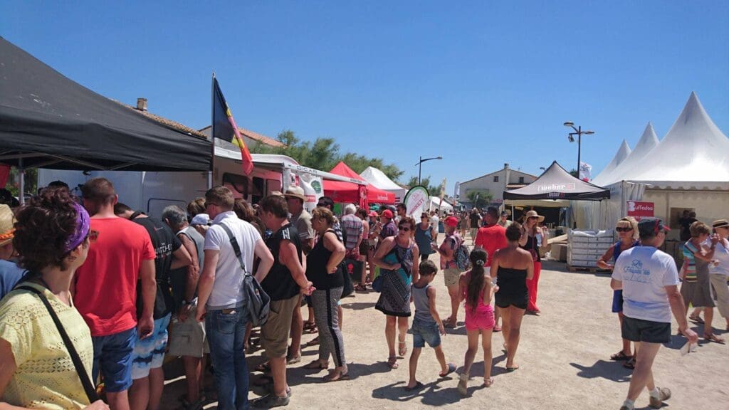 A crowd of people standing around tents on the street.